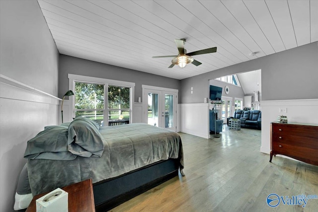 bedroom with multiple windows, ceiling fan, light hardwood / wood-style flooring, and french doors