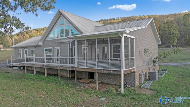 back of house featuring a wooden deck, a sunroom, a yard, and cooling unit