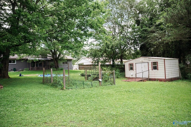 1021 NW 9th St NW, Arab, AL 35016 - view of grassy yard featuring a vegetable garden and a storage shed