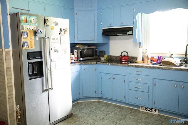 1021 NW 9th St NW, Arab, AL 35016 - kitchen with stainless steel appliances, under cabinet range hood, blue cabinetry, tile patterned floors, and dark countertops