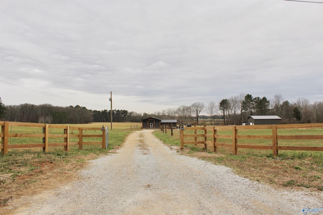 view of road featuring gravel driveway and a rural view