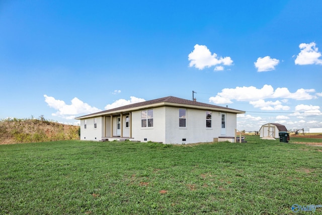 back of property featuring a lawn and a shed