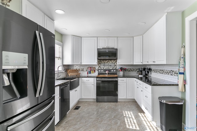 kitchen featuring sink, dark stone countertops, appliances with stainless steel finishes, tasteful backsplash, and white cabinetry