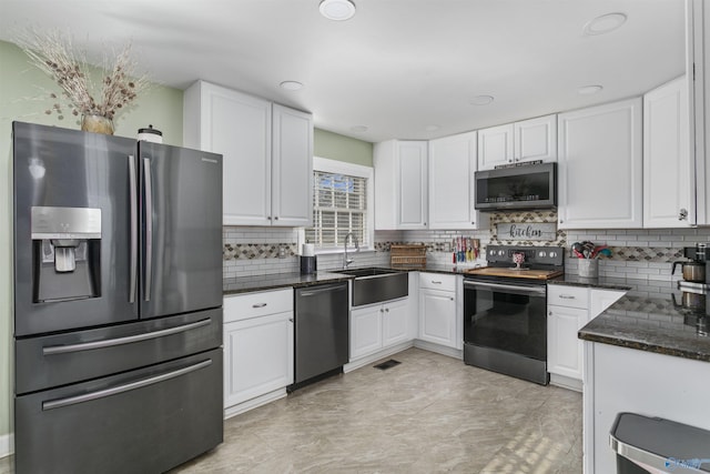 kitchen with white cabinets, sink, appliances with stainless steel finishes, and tasteful backsplash