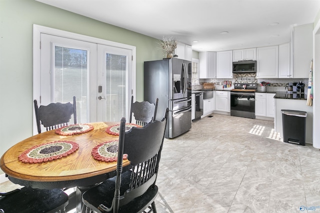 kitchen featuring white cabinets, french doors, appliances with stainless steel finishes, and tasteful backsplash