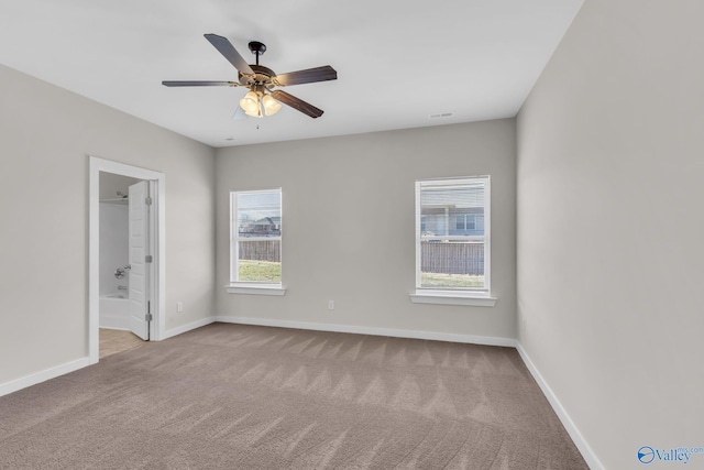 empty room with ceiling fan, a healthy amount of sunlight, and light carpet