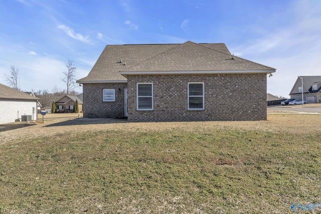 rear view of house featuring a yard and central AC unit