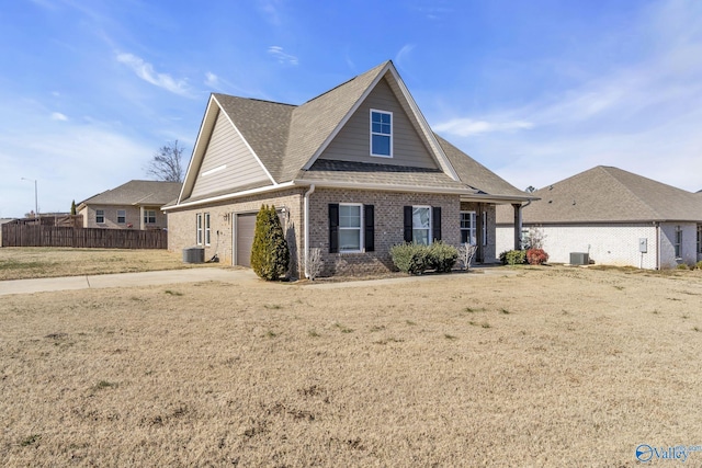 view of front of home with central AC unit and a front lawn