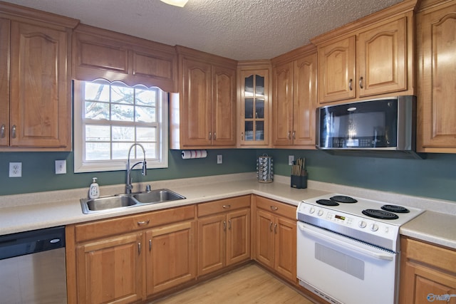 kitchen featuring sink, a textured ceiling, light hardwood / wood-style flooring, dishwasher, and electric stove