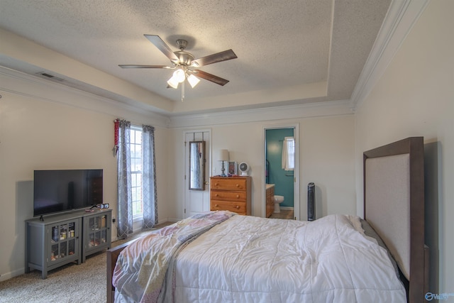 carpeted bedroom featuring ornamental molding, a raised ceiling, and a textured ceiling