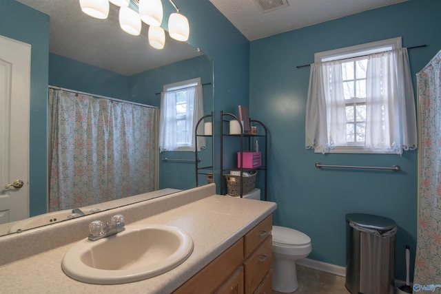 bathroom with a textured ceiling, vanity, toilet, tile patterned floors, and an inviting chandelier