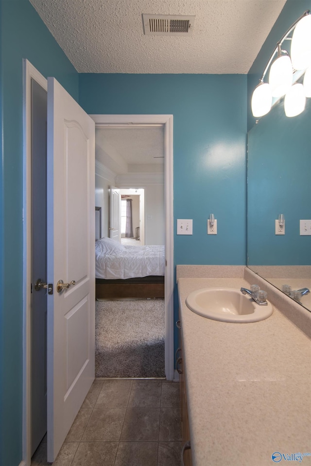 bathroom featuring tile patterned flooring, sink, and a textured ceiling