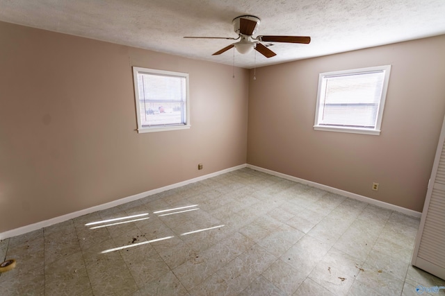 empty room featuring ceiling fan and a textured ceiling