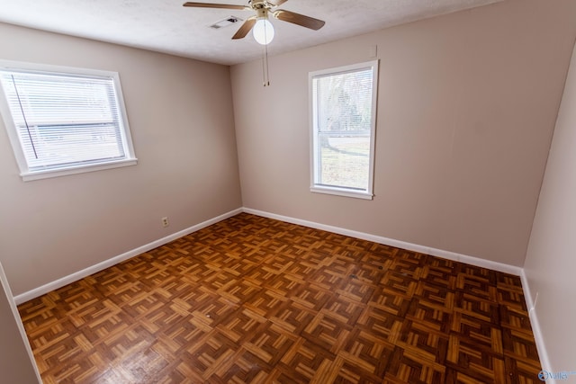 unfurnished room with ceiling fan, dark parquet floors, and a textured ceiling