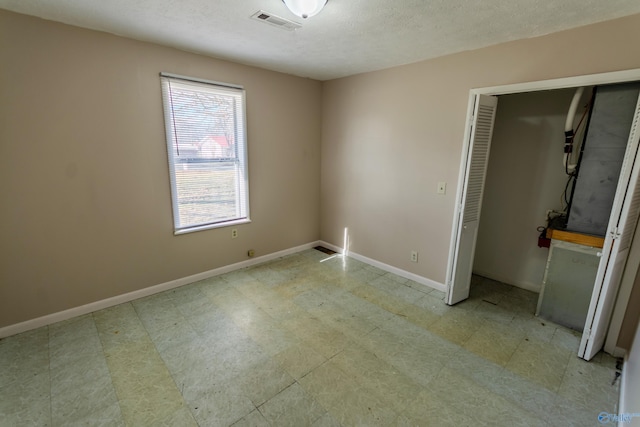 unfurnished bedroom with a textured ceiling and a closet