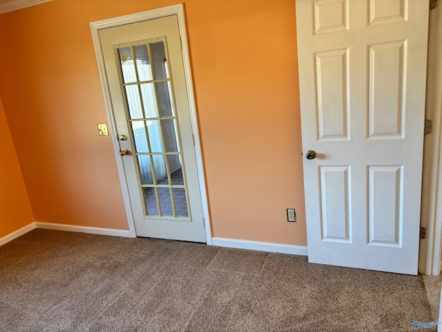 carpeted empty room featuring baseboards