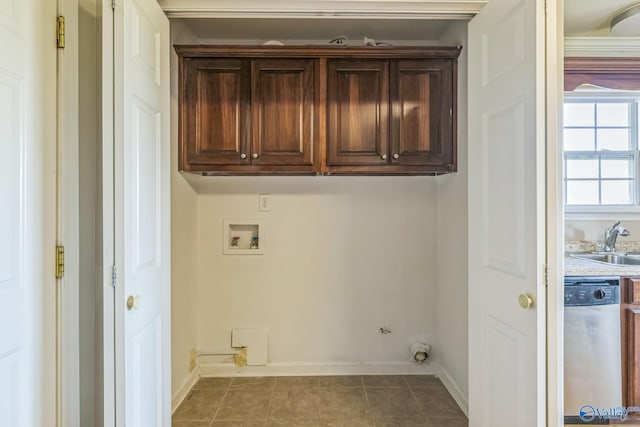 clothes washing area featuring sink, washer hookup, dark tile patterned flooring, and cabinets