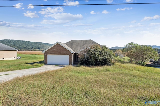 ranch-style home featuring a rural view, a garage, a mountain view, and a front yard