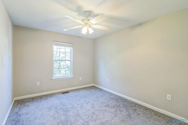 carpeted spare room featuring ceiling fan