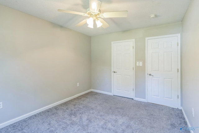 unfurnished bedroom featuring ceiling fan and light carpet