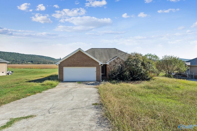 ranch-style house featuring a mountain view, a garage, a front lawn, and a rural view