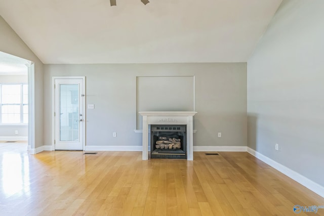 unfurnished living room featuring light hardwood / wood-style flooring, lofted ceiling, and ceiling fan