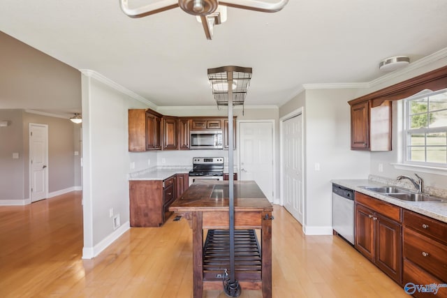 kitchen with ornamental molding, stainless steel appliances, light wood-type flooring, and sink