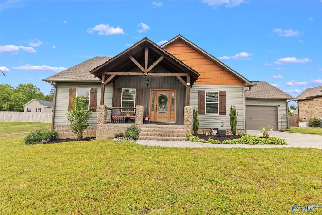 craftsman-style home with a porch, a garage, and a front yard