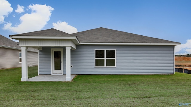 rear view of property featuring a lawn and a patio area