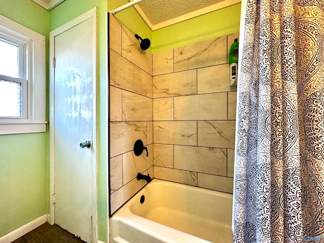 bathroom featuring shower / bath combination with curtain and a textured ceiling