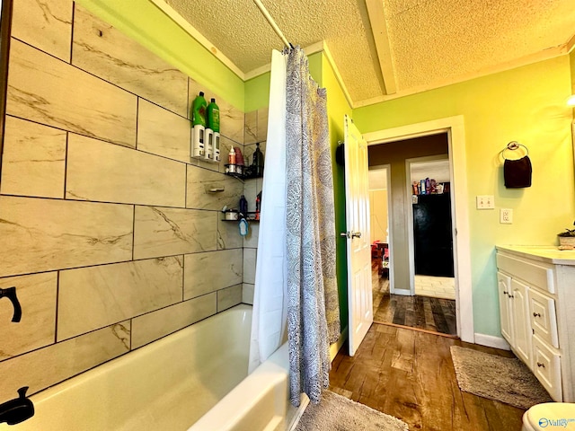 bathroom featuring vanity, ornamental molding, a textured ceiling, wood-type flooring, and shower / tub combo