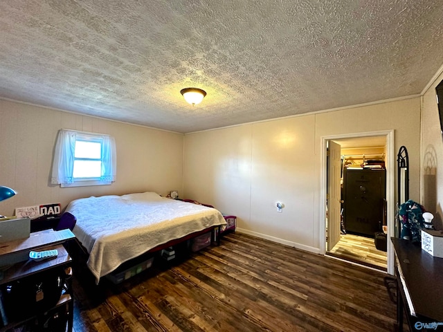 bedroom with a textured ceiling, dark hardwood / wood-style flooring, and a closet