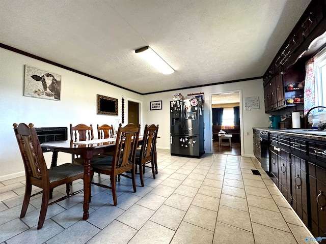 dining room featuring a textured ceiling, light tile patterned floors, sink, and ornamental molding