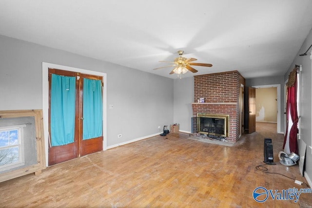 unfurnished living room featuring hardwood / wood-style flooring, ceiling fan, and a fireplace