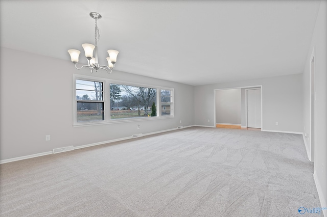 spare room with light carpet and a notable chandelier