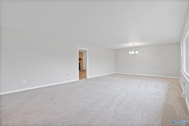 unfurnished room with light carpet and a notable chandelier