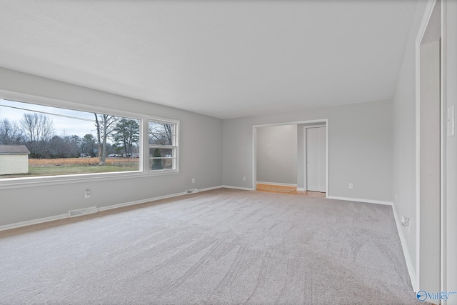 spare room featuring light carpet