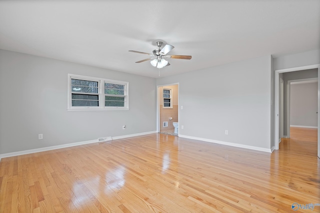 spare room with ceiling fan and light wood-type flooring