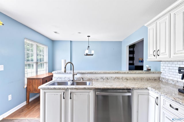 kitchen with kitchen peninsula, backsplash, sink, dishwasher, and white cabinetry