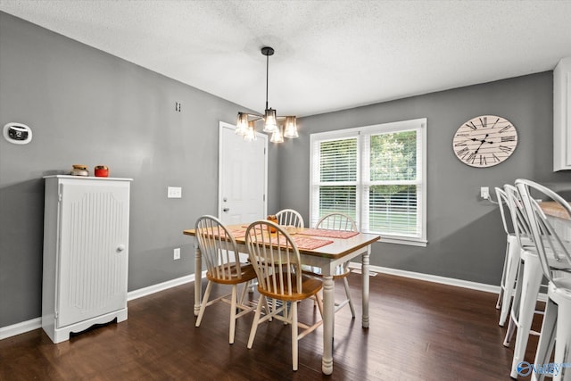 dining space featuring dark hardwood / wood-style floors, an inviting chandelier, and a textured ceiling