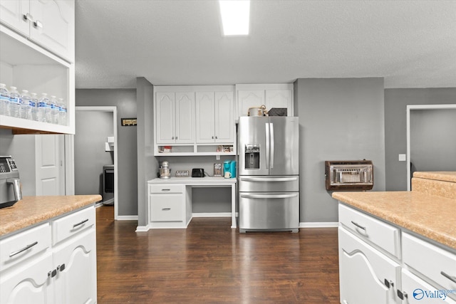 kitchen with a textured ceiling, dark wood-type flooring, white cabinets, and stainless steel refrigerator with ice dispenser