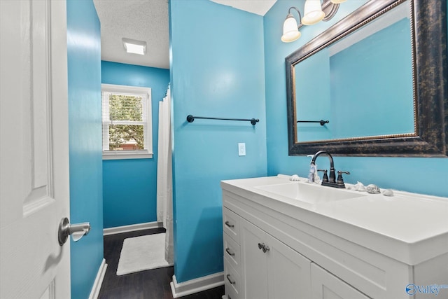 bathroom with curtained shower, hardwood / wood-style flooring, a textured ceiling, and vanity