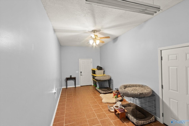 interior space with a textured ceiling and ceiling fan