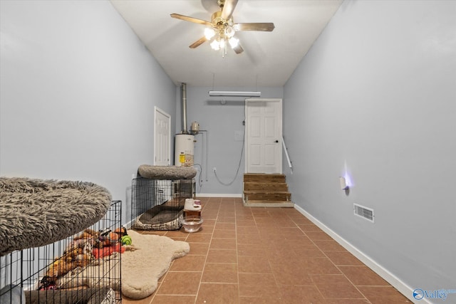 interior space featuring water heater, ceiling fan, and tile patterned flooring