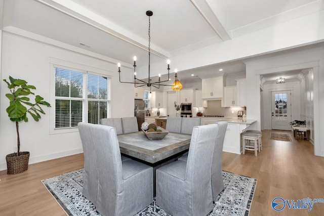 dining area with beam ceiling, an inviting chandelier, and light hardwood / wood-style floors