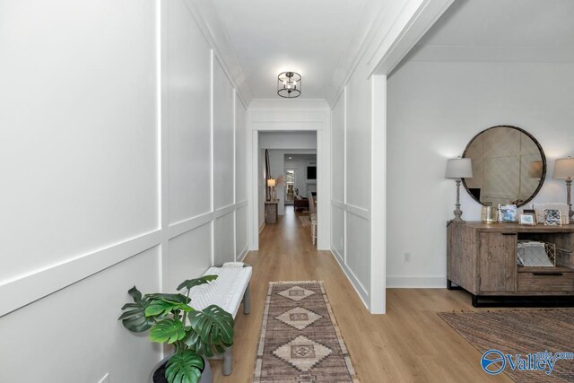 hallway featuring crown molding and light wood-type flooring