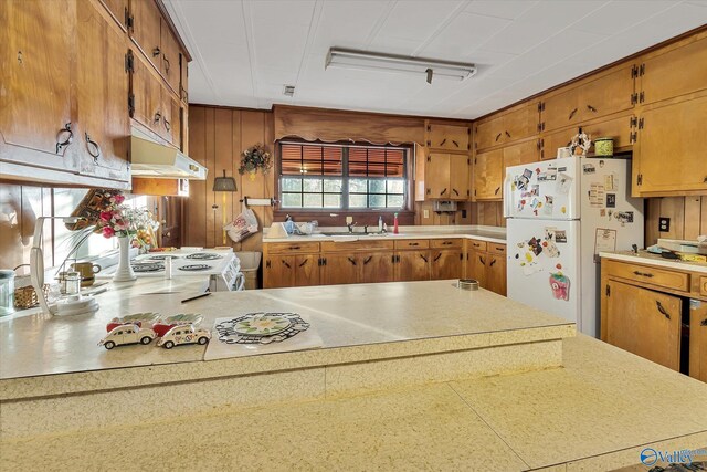 kitchen featuring white appliances, sink, and kitchen peninsula