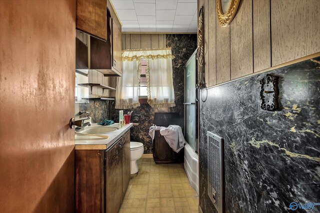 full bathroom featuring shower / bath combination with glass door, vanity, tasteful backsplash, and toilet