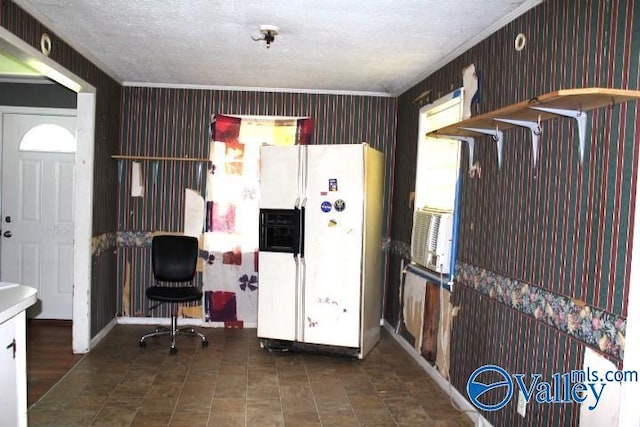 interior space with wallpapered walls, white refrigerator with ice dispenser, and a textured ceiling