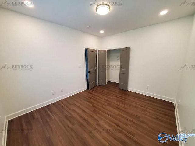 unfurnished bedroom with dark hardwood / wood-style floors and a closet